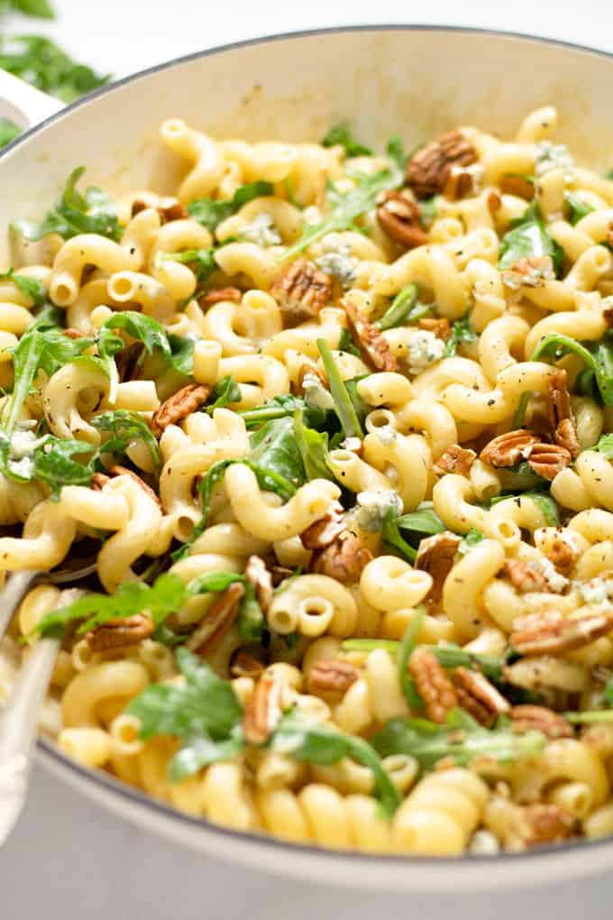 Close up shot of a white pan filled with fresh homemade Gorgonzola pasta with arugula