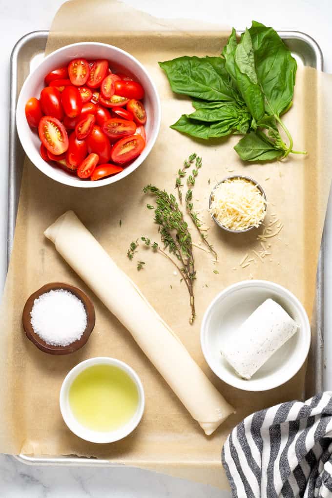 Baking sheet filled with ingredients to make tomato tart