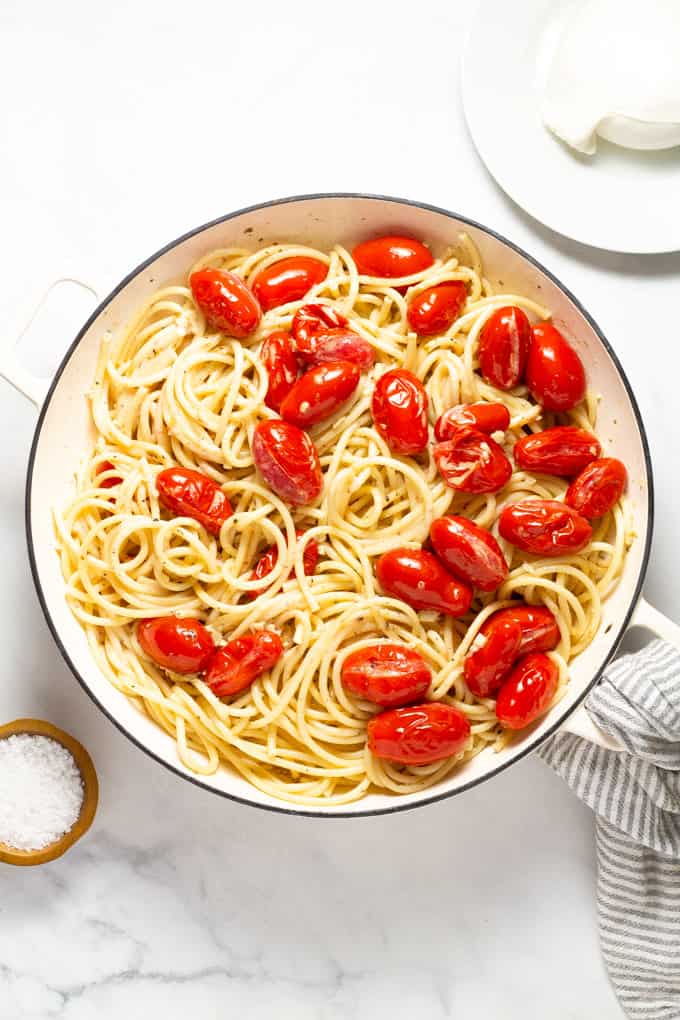 Overhead shot of a pan filled with ingredients to make tomato and garlic pasta