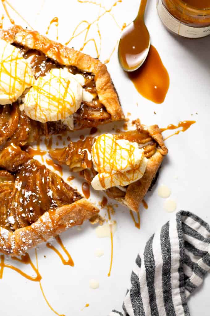 Overhead shot of a slice of an apple tart topped with caramel and ice cream