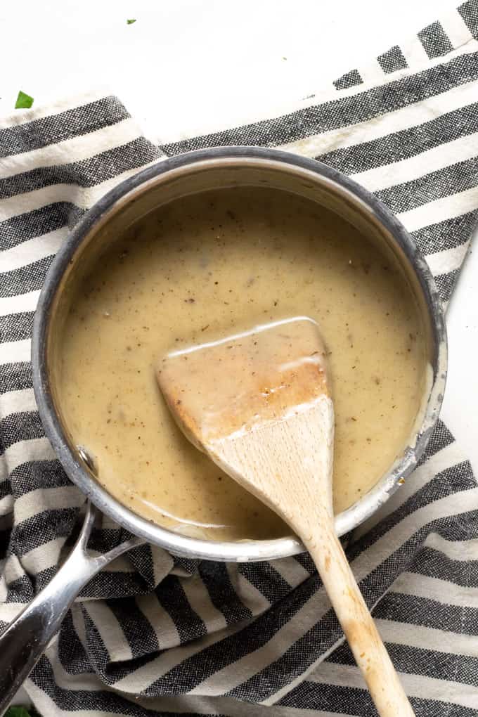A small sauce pan filled with creamy gravy from beer braised short ribs