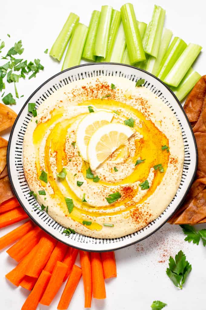 Overhead shot of a plate filled with homemade hummus garnished with olive oil and parsley