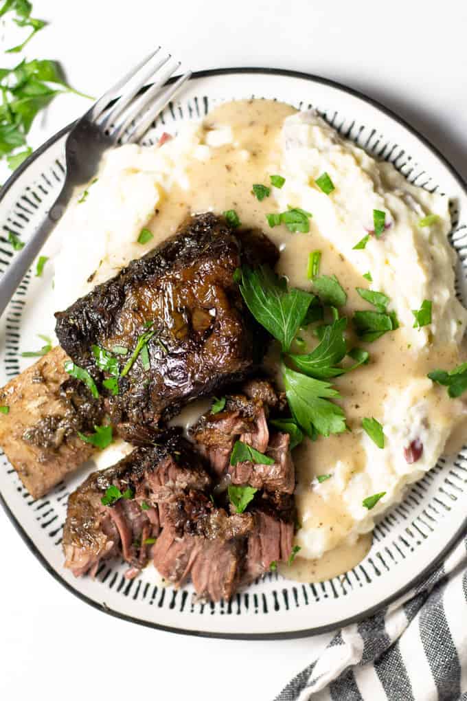 Overhead shot of a white plate filled with homemade garlic mashed potatoes and beef short ribs