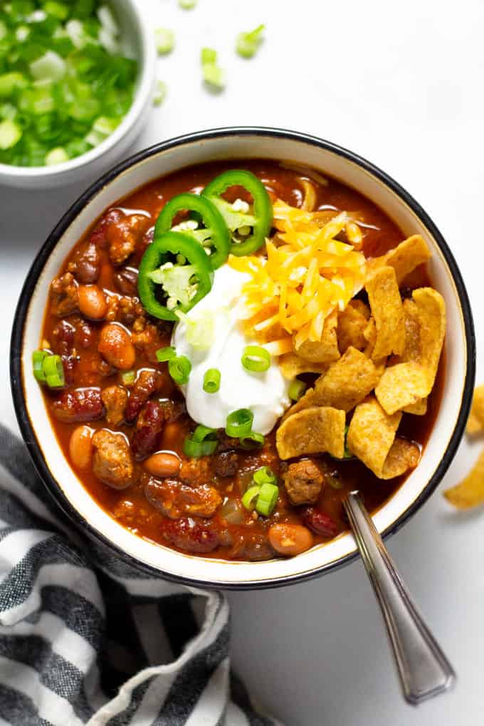 An overhead shot of a bowl of slow cooker turkey chili garnished with sour cream