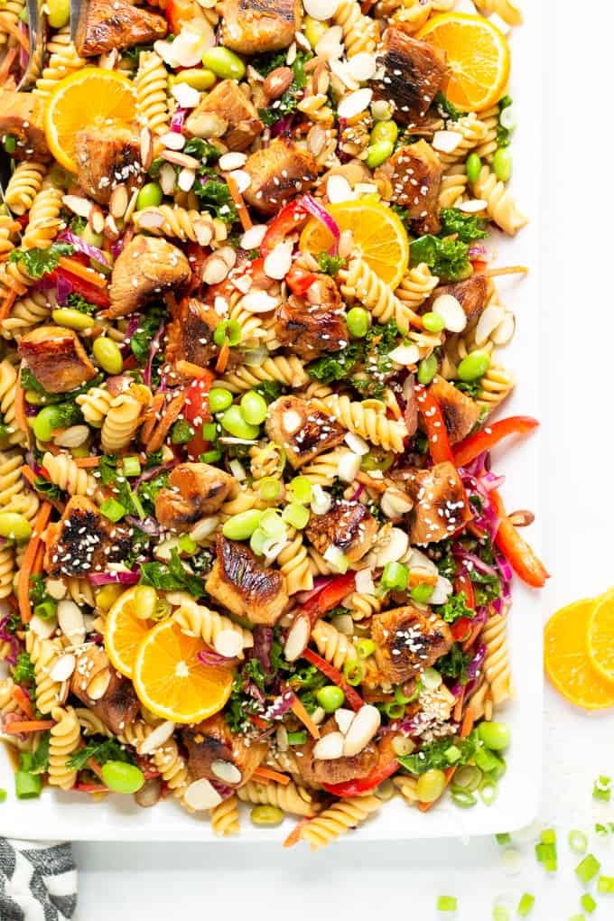 White platter filled with a fresh homemade Asian Chicken Pasta Salad garnished with sesame seeds
