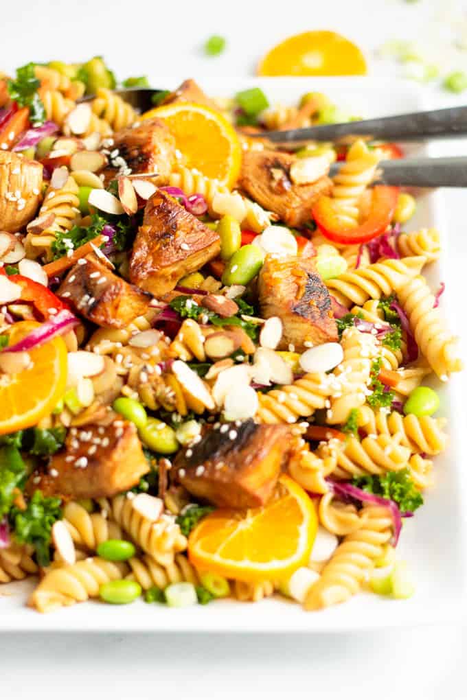 White platter filled with a fresh homemade Asian Chicken Pasta Salad garnished with sesame seeds
