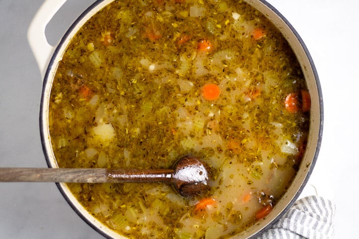 White dutch oven with veggie soup in it