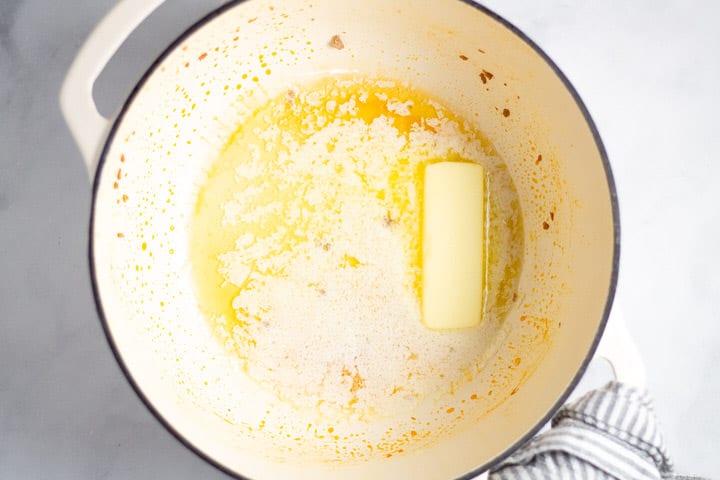 White dutch oven with melted butter in it