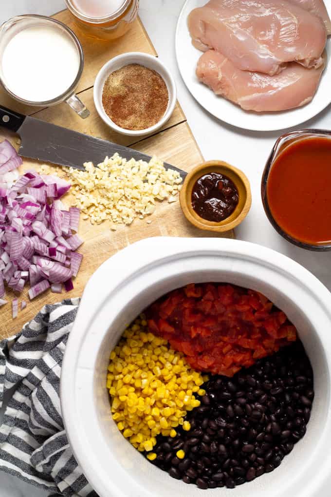 White marble counter top with ingredients to make slow cooker chicken enchilada soup