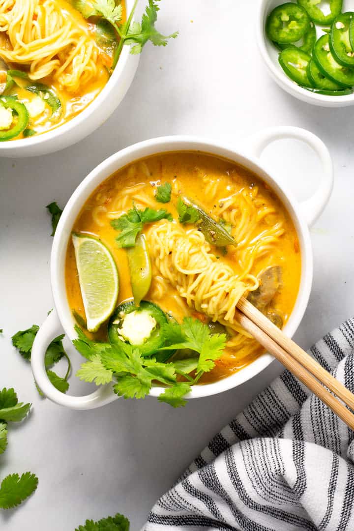 One white bowl filled with vegan curry ramen garnished with fresh cilantro
