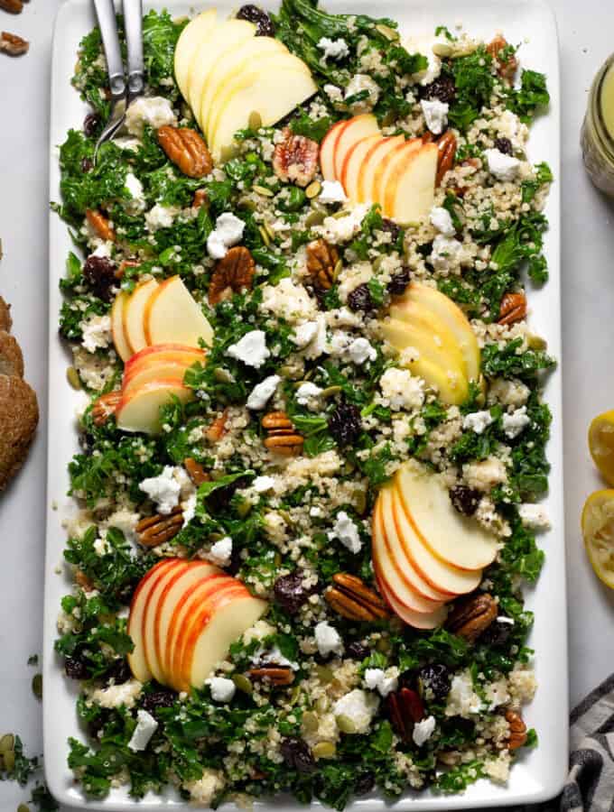 Overhead shot of a large white platter filled with fall harvest salad tossed in cider Dijon vinaigrette