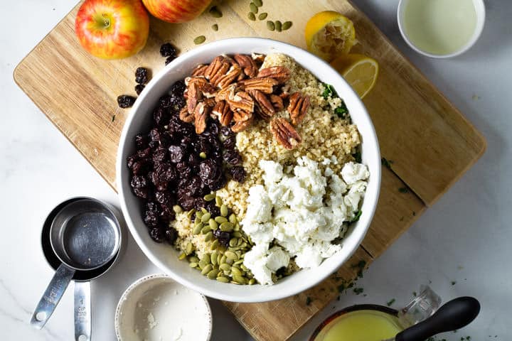 A large white bowl filled with ingredients to make a fall harvest salad