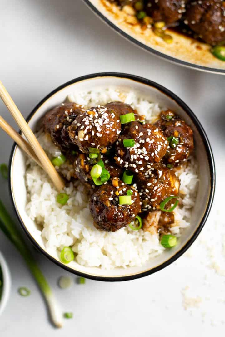Korean beef meatballs on a bed of rice in a black and white bowl 