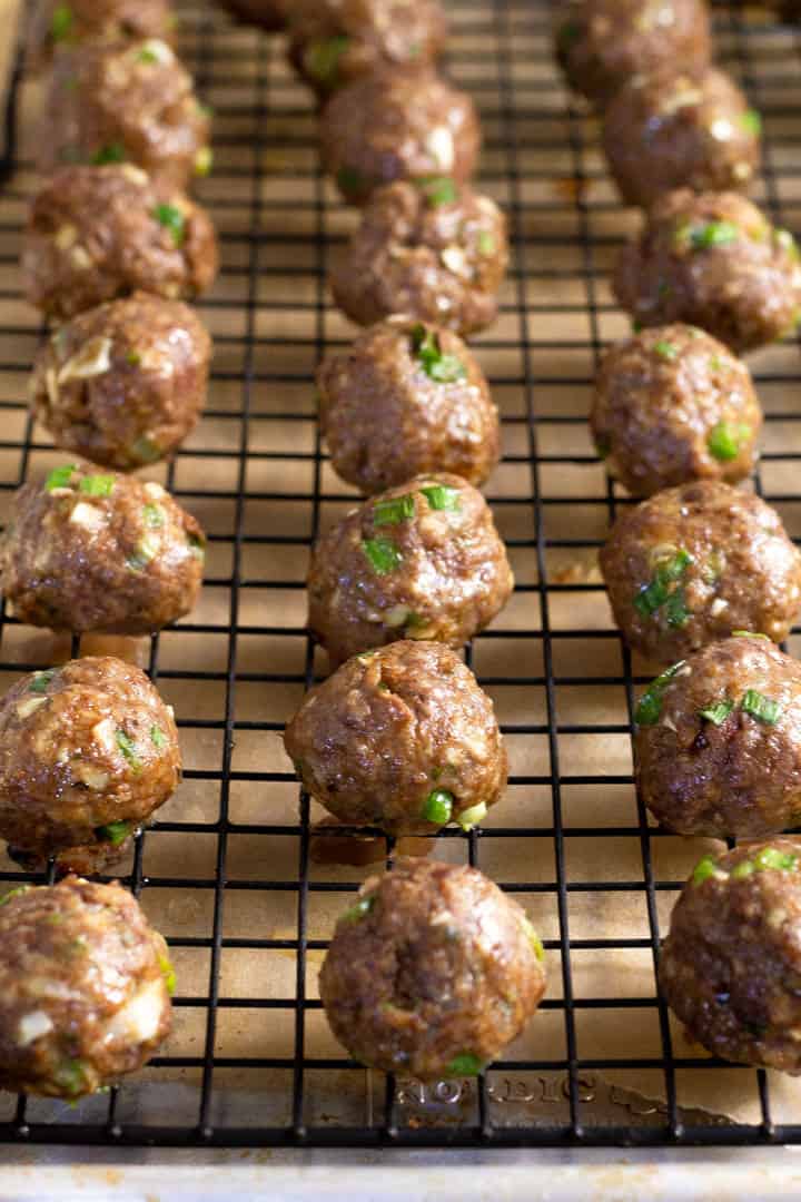 Baked Korean beef meatballs on a cooling rack on a baking sheet 