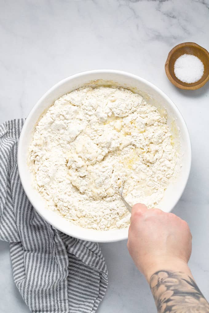 White bowl filled with ingredients to make no knead pizza dough
