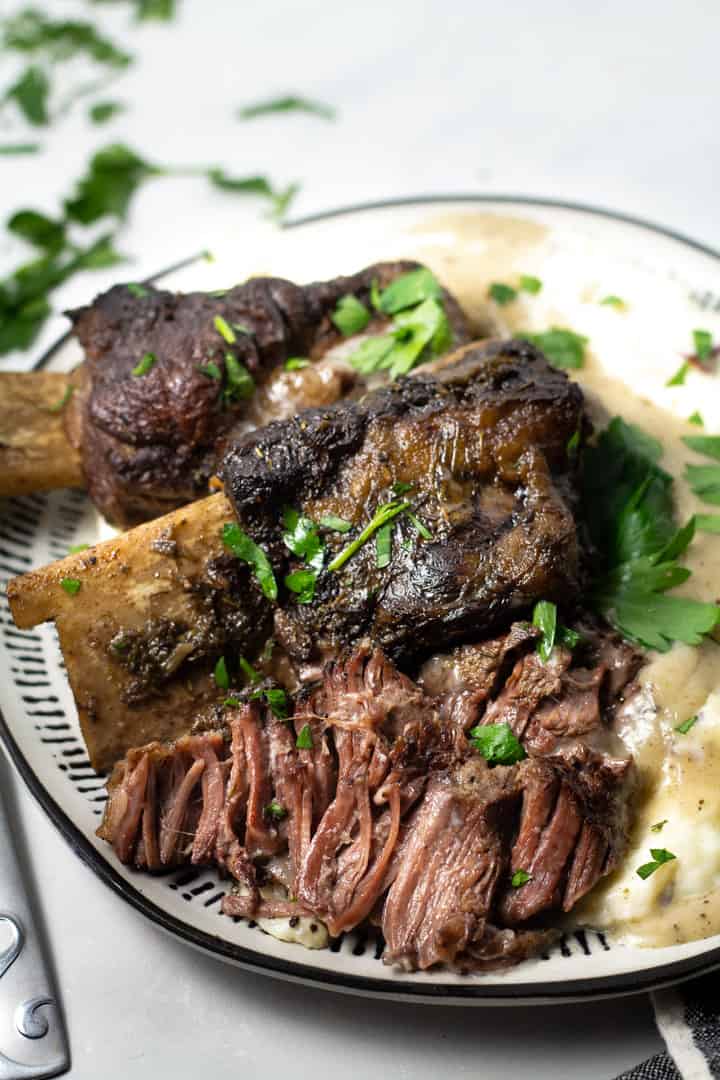 Overhead shot of a plate filled with short ribs and homemade mashed potatoes garnished with parsley