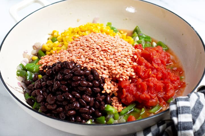White saute pan corn green pepper black beans and tomatoes