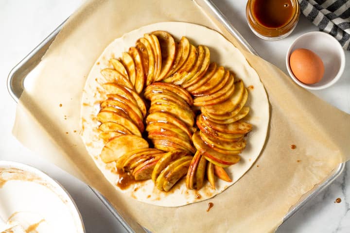Pie crust filled with sliced apples coated in sugar and spices