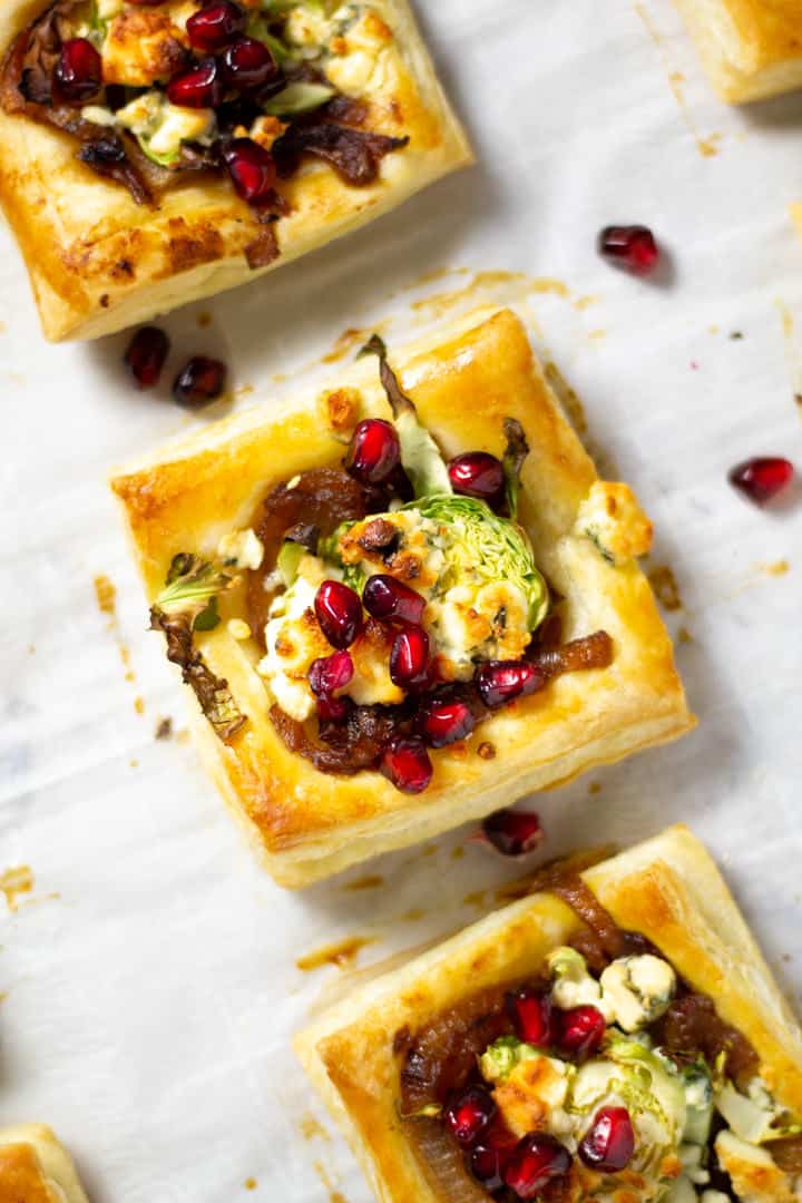 Close up shot of a Brussels sprout tart topped with pomegranate seeds