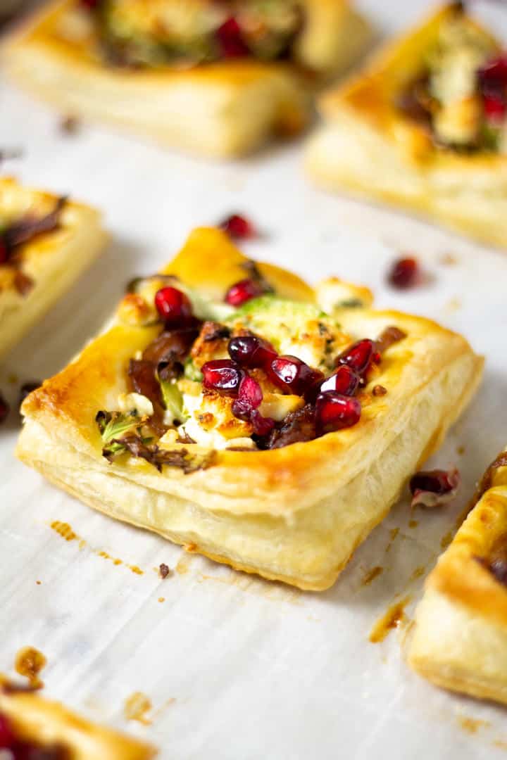 Close up shot of Brussels sprout tarts on a parchment lined baking sheet