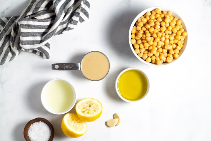 White marble counter top with ingredients to make hummus
