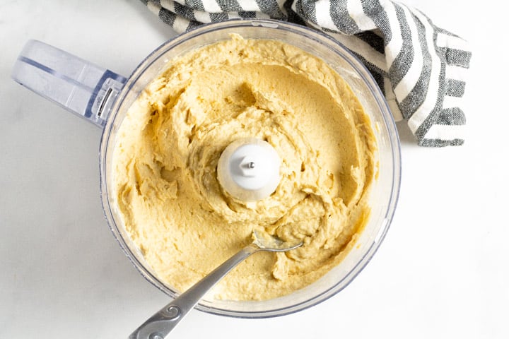 Food processor filled with ingredients to make homemade hummus