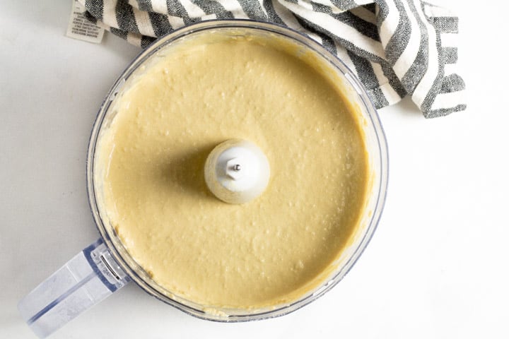 Food processor filled with ingredients to make homemade hummus