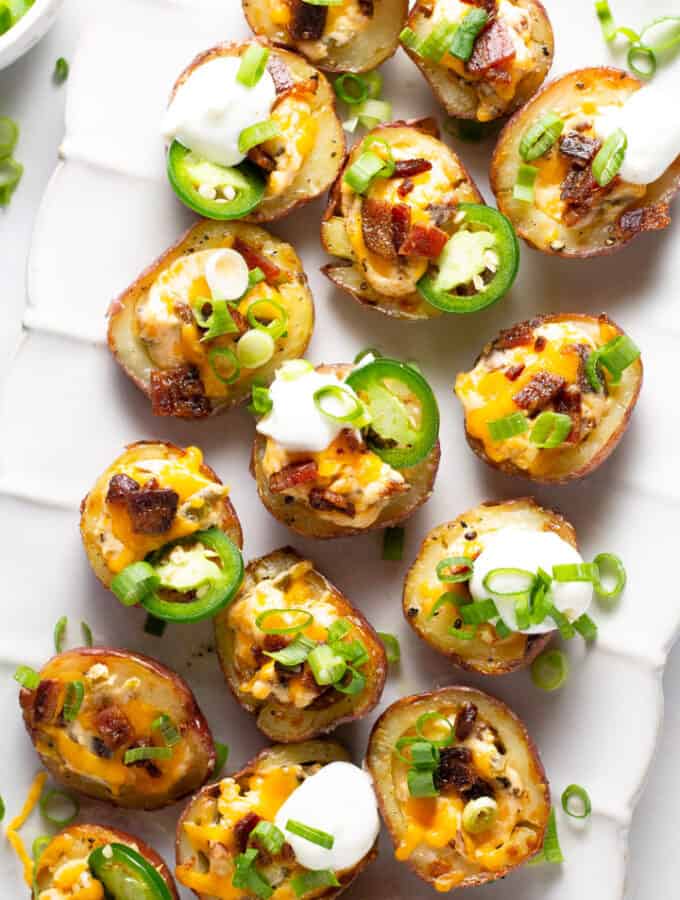 Overhead shot of jalapeno popper potato skins on a white serving platter