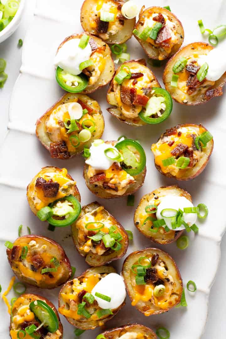 Overhead shot of jalapeno popper potato skins on a white serving platter