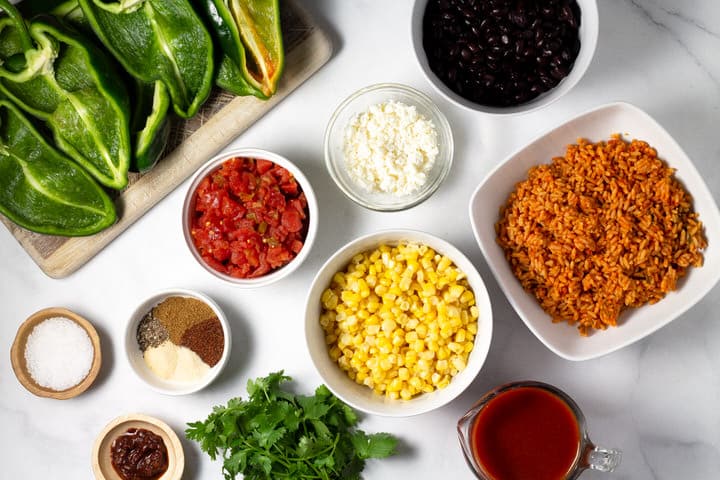 White marble counter top with ingredients to make vegetarian stuffed peppers