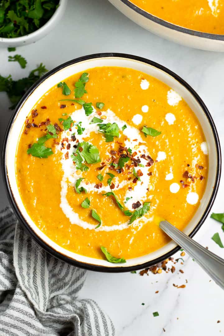 Overhead shot of a black and white bowl filled with vegan butternut squash soup