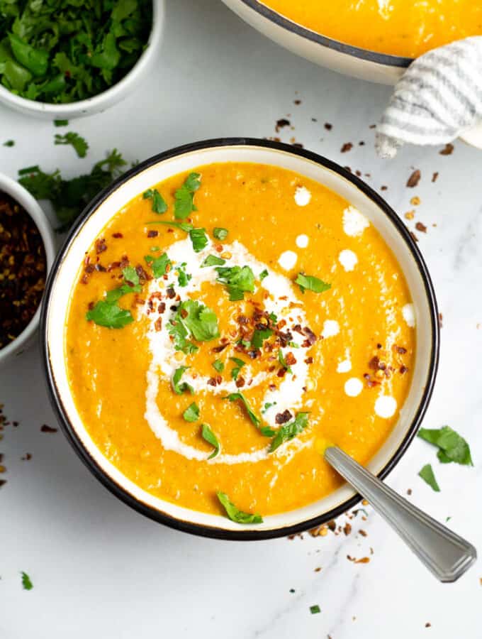 Overhead shot of a black and white bowl filled with vegan butternut squash soup