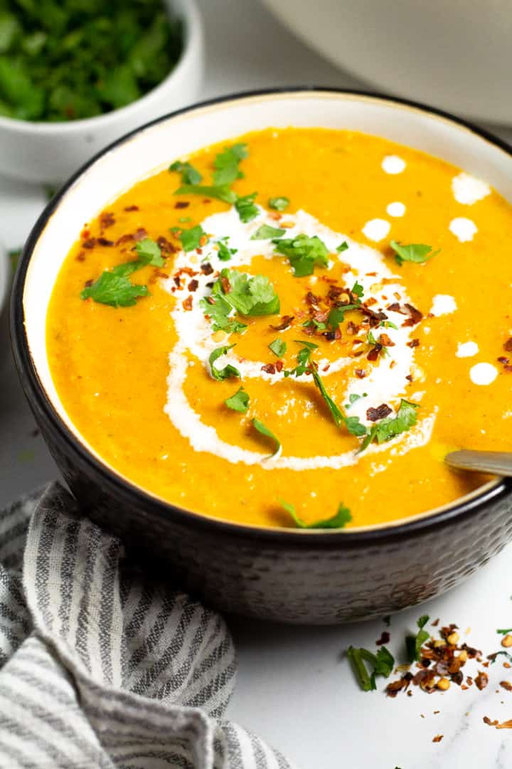 Close up shot of a black and white bowl filled with vegan butternut squash soup
