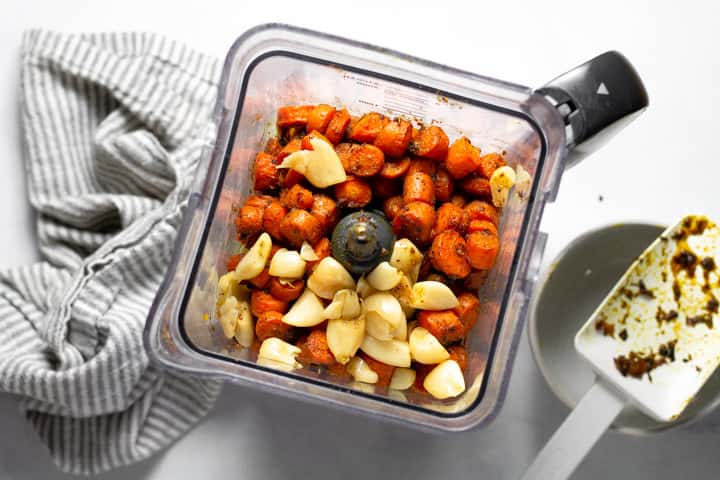 Overhead shot of a blender filled with roasted squash carrots and garlic