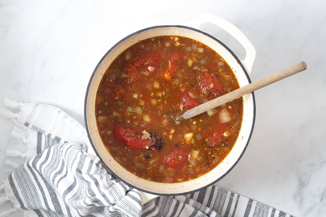 Large white pot filled with ingredients to make vegan tomato soup