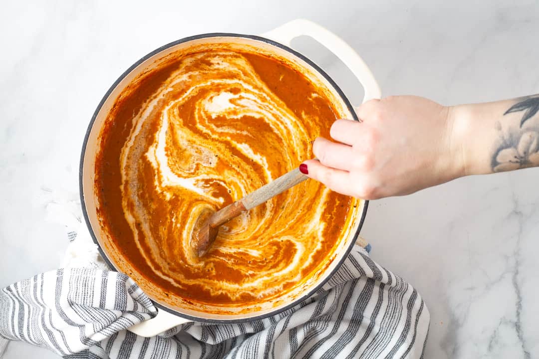 Large white pot filled with creamy vegan tomato soup