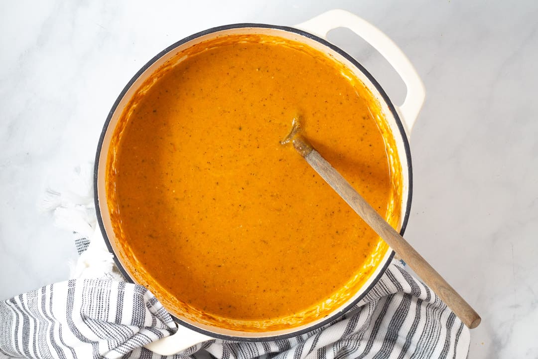 Large white pot filled with creamy vegan tomato soup