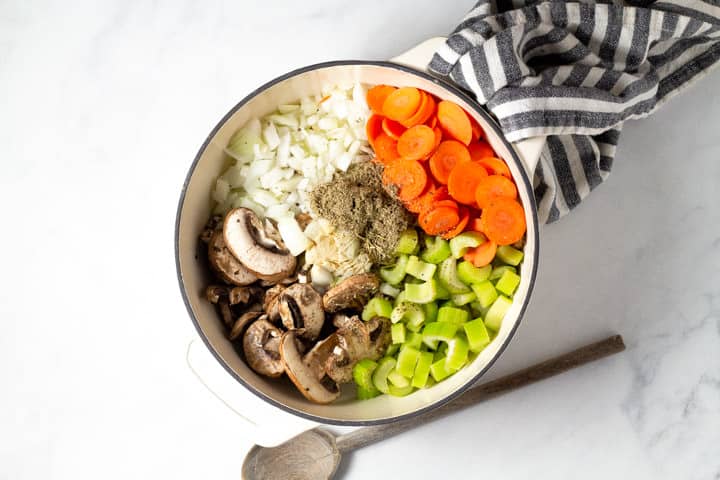 Large dutch oven filled with veggies for wild rice soup