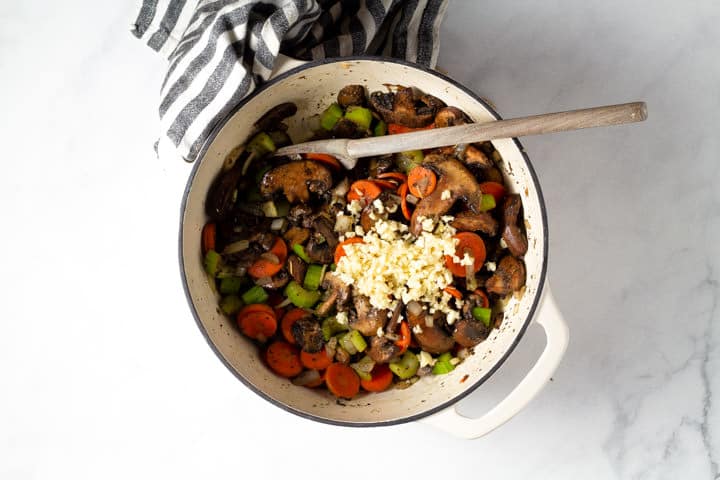 Large dutch oven filled with veggies for wild rice soup