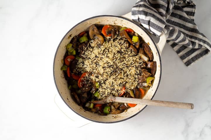 Large dutch oven filled with veggies for wild rice soup