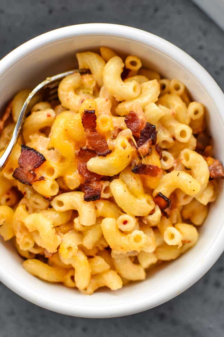 Overhead shot of bacon mac and cheese in a white bowl