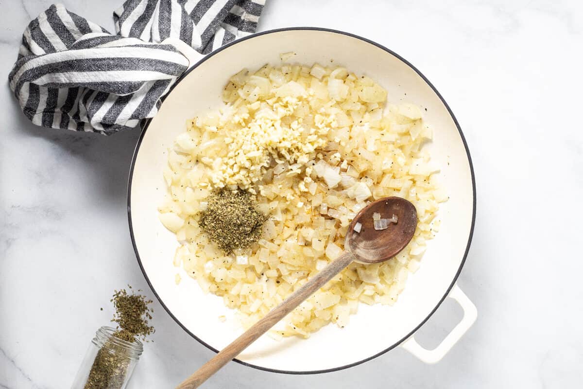 Large white saute pan filled with sauteed onions