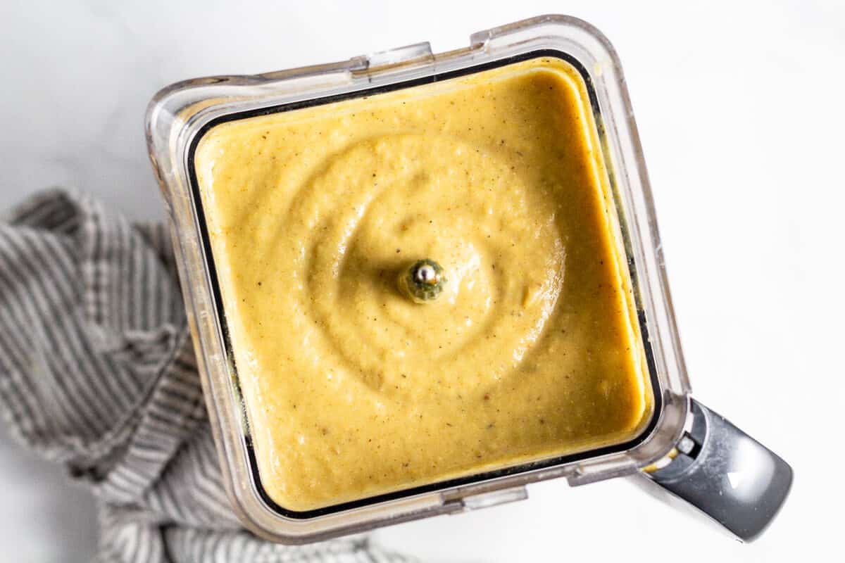 Overhead shot of a blender filled with creamy vegan cauliflower soup 