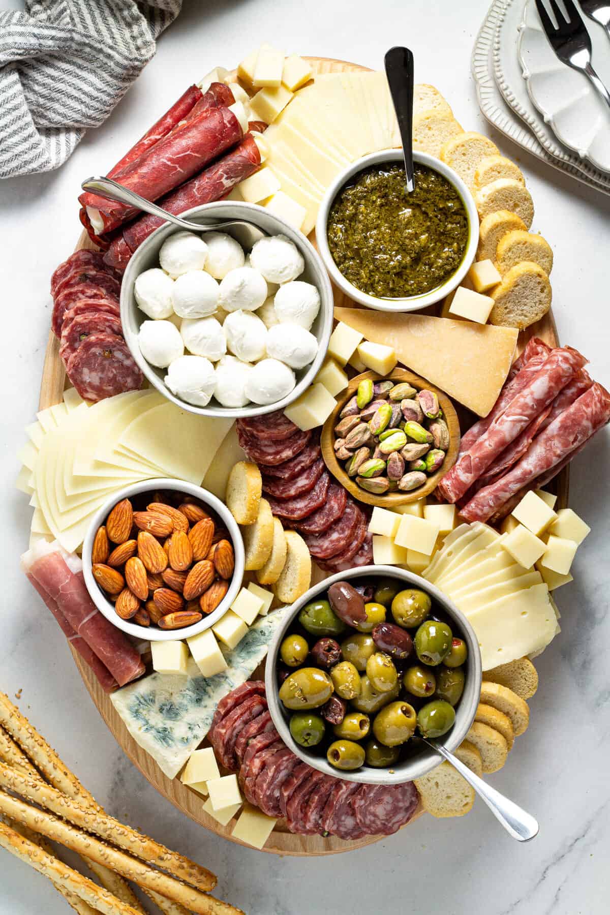 Overhead shot of a cheese board filled with a variety of meats cheeses and nuts