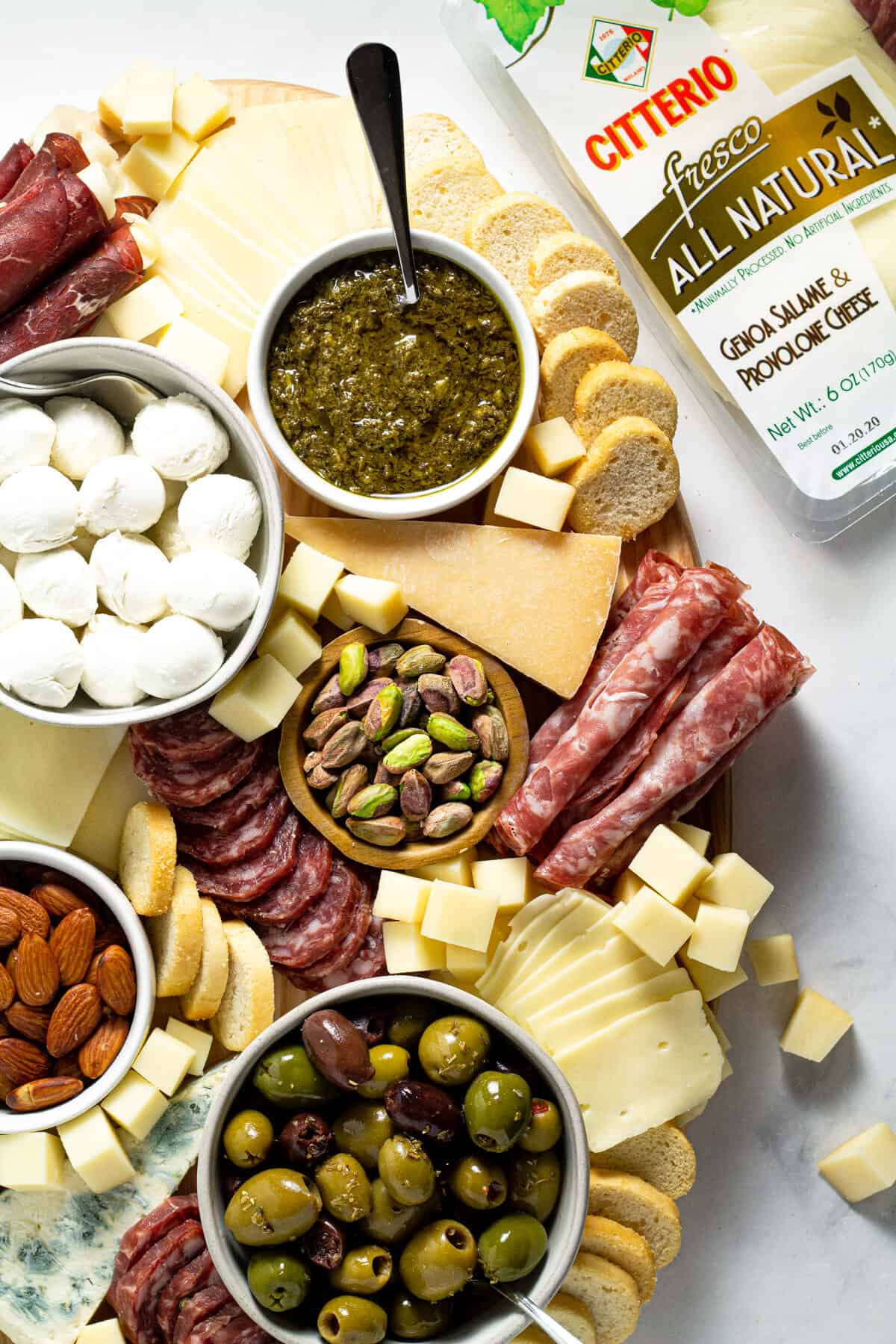 Overhead shot of a cheese board filled with a variety of meats cheeses and nuts