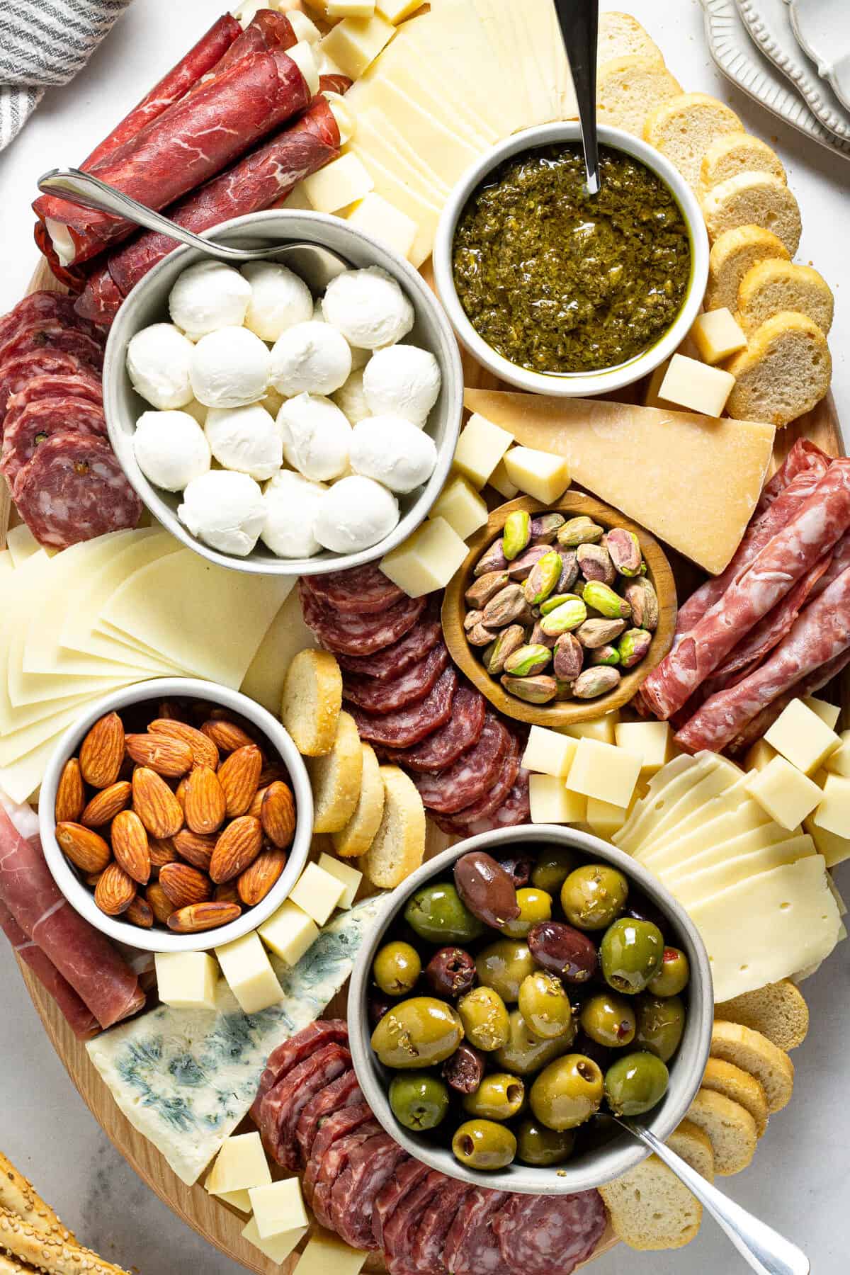 Overhead shot of a cheese board filled with a variety of meats cheeses and nuts