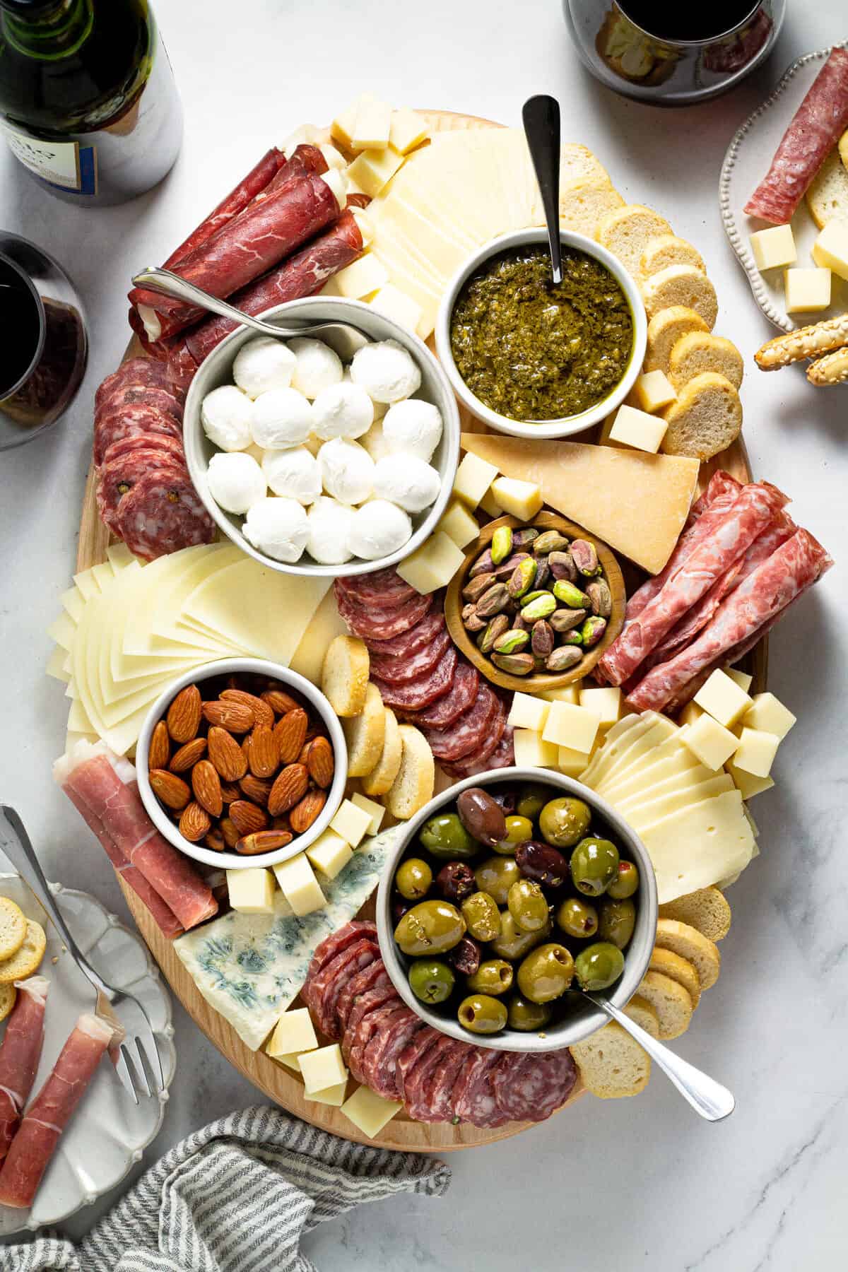 Overhead shot of a cheese board filled with a variety of meats cheeses and nuts