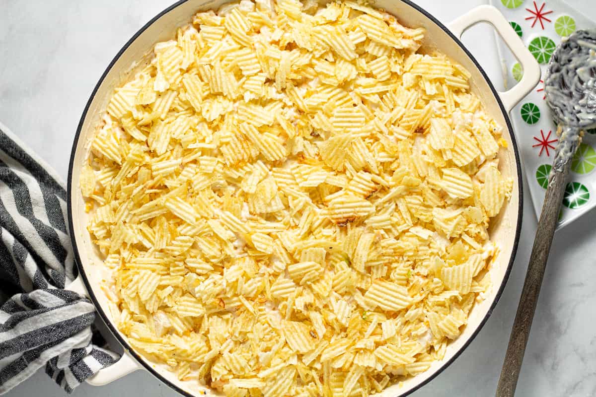 Large white pan filled with ingredients to make cheesy potatoes