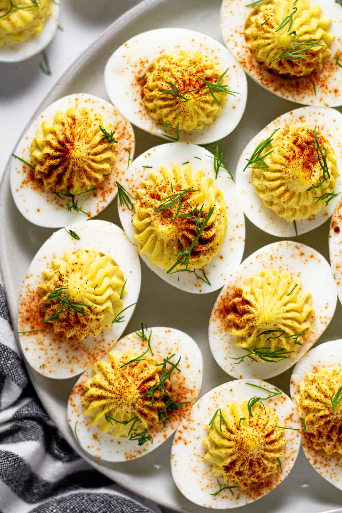 Overhead shot of several curry deviled eggs on a white marble counter top 