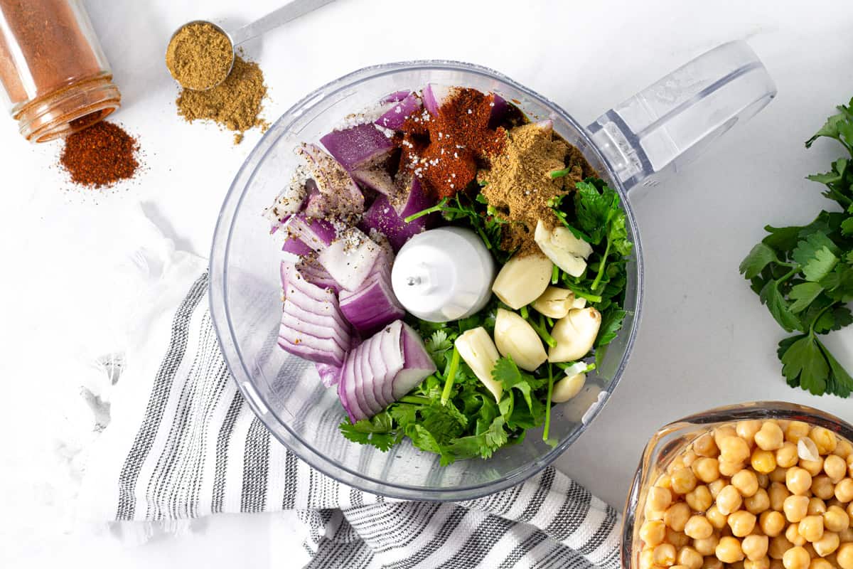 Food processor filled with ingredients to make falafel